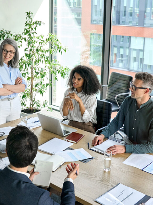 Diverse corporate team working together in modern meeting room office.